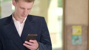 Man sms texting using app on smart phone at night in city. Handsome young business man using smartphone smiling happy stock footage Man sms texting using app on smart phone at night in city. Handsome young business man using smartphone smiling happy stock footage