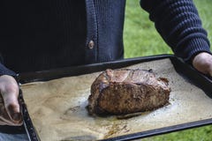 Man som rymmer grillat steknötkött på ett mörkt bräde arkivbilder Man som rymmer grillat steknötkött på ett mörkt bräde arkivbilder