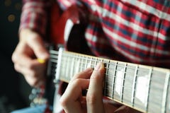 Man som spelar på den elektriska gitarren mot mörk bakgrund arkivfoton Man som spelar på den elektriska gitarren mot mörk bakgrund arkivfoton