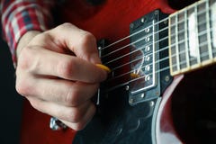 Man som spelar på den elektriska gitarren mot mörk bakgrund arkivfoton Man som spelar på den elektriska gitarren mot mörk bakgrund arkivfoton