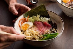 Man som äter asiatiska ramen med tonfisk och nudlar i en restaurang fotografering för bildbyråer Man som äter asiatiska ramen med tonfisk och nudlar i en restaurang fotografering för bildbyråer