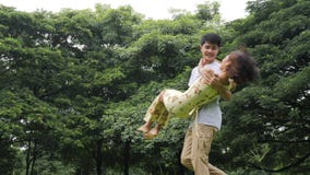 Man spinning his girlfriend in a park. stock video Man spinning his girlfriend in a park. stock video