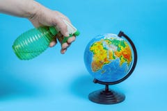 A man spray a globe from a green bottle royalty free stock image A man spray a globe from a green bottle royalty free stock image