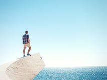 Man standing on a cliff and sea Royalty Free Stock Images Man standing on a cliff and sea Royalty Free Stock Images