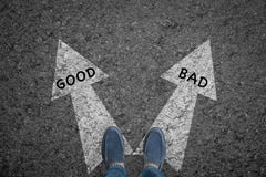 Man standing on road with direction arrow choices Good and Bad Royalty Free Stock Image Man standing on road with direction arrow choices Good and Bad Royalty Free Stock Image
