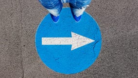Man standing on the turn right traffic road sign symbol with white arrow pointing right stock photos Man standing on the turn right traffic road sign symbol with white arrow pointing right stock photos