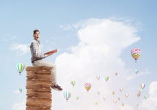 Man student on stack reading book and aerostats flying around stock photography Man student on stack reading book and aerostats flying around stock photography