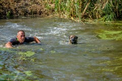 Man swims with his dog in the Happy Dog Survival contest 2016. stock photography Man swims with his dog in the Happy Dog Survival contest 2016. stock photography