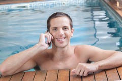 Man talking on cell inside the pool Stock Photo Man talking on cell inside the pool Stock Photo