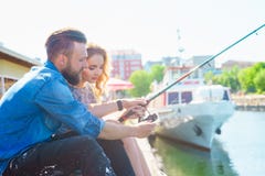 Man teaching his girlfriend to fishing. Date, love and hobby concept. stock photography Man teaching his girlfriend to fishing. Date, love and hobby concept. stock photography