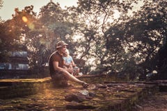 Man traveler with child daughter resting together on ruins at sunset during vacation concept travelling lifestyle stock photos Man traveler with child daughter resting together on ruins at sunset during vacation concept travelling lifestyle stock photos