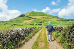 A man with trekking poles walking along a country road, Azores, Stock Photos A man with trekking poles walking along a country road, Azores, Stock Photos