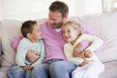 Man and two children sitting in living room stock photography Man and two children sitting in living room stock photography