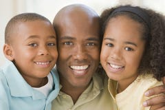 Man and two young children embracing and smiling stock image Man and two young children embracing and smiling stock image