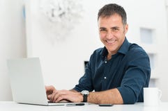 Man Using Laptop At Desk royalty free stock image Man Using Laptop At Desk royalty free stock image