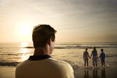 Man watching family at beach