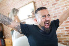 Man watching television and woman is arguing in background stock photos Man watching television and woman is arguing in background stock photos