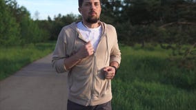 Man who is engaged in sports running is preparing for a sprint in the park area stock video footage Man who is engaged in sports running is preparing for a sprint in the park area stock video footage
