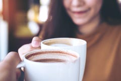 Man and woman clink coffee mugs in cafe Stock Photos Man and woman clink coffee mugs in cafe Stock Photos