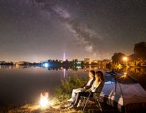 Man and woman having a rest on shore under night sky stock photography Man and woman having a rest on shore under night sky stock photography