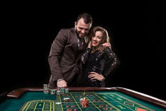 Man and woman playing at roulette table in casino stock photo Man and woman playing at roulette table in casino stock photo