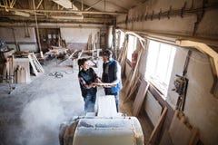 Man and woman workers in the carpentry workshop holding wood. Royalty Free Stock Photo Man and woman workers in the carpentry workshop holding wood. Royalty Free Stock Photo