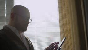 Man working in office with tablet. Business people developing a business project and analyzing market data information stock footage Man working in office with tablet. Business people developing a business project and analyzing market data information stock footage