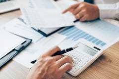 Manager Calculates About The Company Finances By Pressing On The Calculator On The Table With The Employee Explaining The Summary Stock Photo