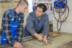 Manager showing trainee how to work with blowtorch stock image Manager showing trainee how to work with blowtorch stock image