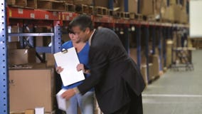 Manager And Worker Checking Goods In Warehouse