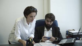 Manageress που παρουσιάζει έγγραφα στον προϊστάμενό της στην αρχή Ο προϊστάμενος παίζει στο τηλέφωνό του κατά τη διάρκεια της συν απόθεμα βίντεο Manageress που παρουσιάζει έγγραφα στον προϊστάμενό της στην αρχή Ο προϊστάμενος παίζει στο τηλέφωνό του κατά τη διάρκεια της συν απόθεμα βίντεο