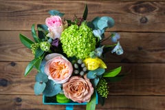 Mand van bloemen en heerlijke dessertmakarons op een houten achtergrond stock foto Mand van bloemen en heerlijke dessertmakarons op een houten achtergrond stock foto