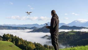 Manfungerande surrflyg eller sväva vid fjärrkontroll med härligt dimmigt landskap i bakgrunden arkivfoton Manfungerande surrflyg eller sväva vid fjärrkontroll med härligt dimmigt landskap i bakgrunden arkivfoton
