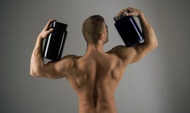 Mangez une alimentation saine Bouteilles de supplément de prise d'homme fort Homme musculaire avec des suppléments de vitamine Sp photo stock Mangez une alimentation saine Bouteilles de supplément de prise d'homme fort Homme musculaire avec des suppléments de vitamine Sp photo stock
