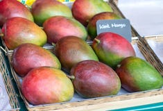 Mangues mûres dans une boîte sur le marché Parts oranges d'ananas et de kiwi photo libre de droits Mangues mûres dans une boîte sur le marché Parts oranges d'ananas et de kiwi photo libre de droits