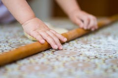 Mani che cuociono pasta con il matterello sulla tavola il piccolo cuoco unico cuoce in cucina Immagine Stock Mani che cuociono pasta con il matterello sulla tavola il piccolo cuoco unico cuoce in cucina Immagine Stock