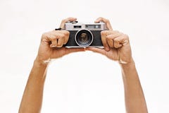 Mani che giudicano una macchina fotografica di Wintage isolata su bianco fotografia stock libera da diritti Mani che giudicano una macchina fotografica di Wintage isolata su bianco fotografia stock libera da diritti
