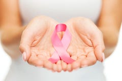 Mani che tengono il nastro rosa di consapevolezza del cancro al seno fotografia stock Mani che tengono il nastro rosa di consapevolezza del cancro al seno fotografia stock