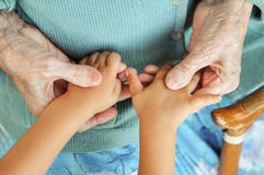 Mani del ` una s dei bambini della tenuta della donna degli anziani, una canna di legno sulla via bisnonna e pronipote immagine stock Mani del ` una s dei bambini della tenuta della donna degli anziani, una canna di legno sulla via bisnonna e pronipote immagine stock