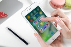 Mani della donna facendo uso dello smartphone con le icone del facebook sociale di media, instagram, cinguettio, applicazione di immagini stock Mani della donna facendo uso dello smartphone con le icone del facebook sociale di media, instagram, cinguettio, applicazione di immagini stock