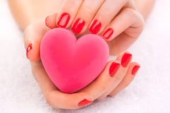 Manicura roja con la caja de regalo en la toalla blanca fotografía de archivo libre de regalías Manicura roja con la caja de regalo en la toalla blanca fotografía de archivo libre de regalías