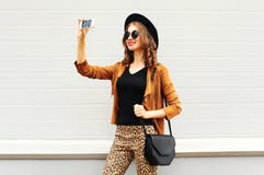 Manier gelukkige jonge glimlachende vrouw die het zelf-portret van het fotobeeld op smartphone nemen die retro elegante hoed, zon stock foto's Manier gelukkige jonge glimlachende vrouw die het zelf-portret van het fotobeeld op smartphone nemen die retro elegante hoed, zon stock foto's
