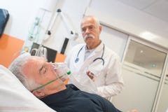 Manipulera att se den höga manliga patienten som inhalerar till och med syremaskering royaltyfri fotografi Manipulera att se den höga manliga patienten som inhalerar till och med syremaskering royaltyfri fotografi