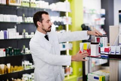 Manlig apotekare som söker efter höger medicin Arkivfoto Manlig apotekare som söker efter höger medicin Arkivfoto