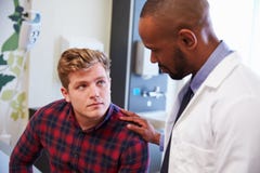 Manlig patient som uppmuntras av doktor In Hospital Room royaltyfria bilder Manlig patient som uppmuntras av doktor In Hospital Room royaltyfria bilder