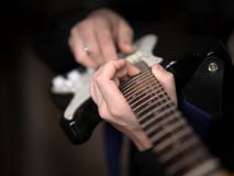 Manliga händer som spelar på den elektriska gitarren, slut upp, utvald fokus royaltyfria foton Manliga händer som spelar på den elektriska gitarren, slut upp, utvald fokus royaltyfria foton