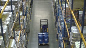 Mann auf dem Gabelstapler, der Fässer im Lager transportiert Mann auf dem Gabelstapler, der Fässer im Lager transportiert