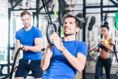 Mann an den Ringen, die Eignungsübung in der Turnhalle tun lizenzfreies stockbild Mann an den Ringen, die Eignungsübung in der Turnhalle tun lizenzfreies stockbild