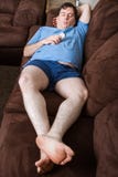 Mann, der auf der Couch niederlegt lizenzfreie stockbilder Mann, der auf der Couch niederlegt lizenzfreie stockbilder