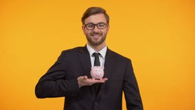 Mann, der Münze in Sparschwein, in Familienbudgetplanung, in Einsparungen und in Finanzierung einsetzt stock footage Mann, der Münze in Sparschwein, in Familienbudgetplanung, in Einsparungen und in Finanzierung einsetzt stock footage